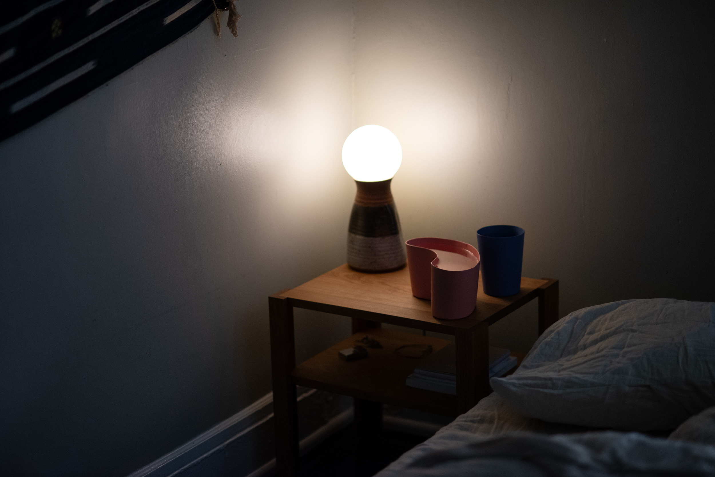 image of the nighstand with two steel cups on top and a lamp in the background